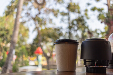 Paper coffee mugs filled with hot coffee are placed on the counter inside the coffee shop for the convenience of customers to take home, and the paper coffee cups are also easy to recycle.