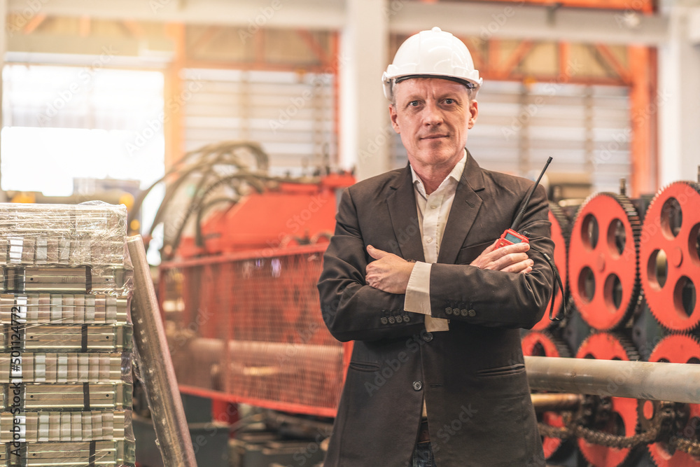 Wall mural white factory owner, senior man wearing a suit, wearing an engineer's hat, arms crossed, holding a r