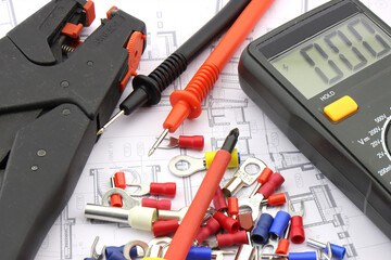 Tools for electrical installation on a close-up schematic diagram.
