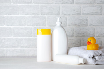 Baby bath accessories, towel, yellow rubber duck and shampoo bottles. The concept of child care.