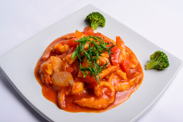 Shrimp in tomato sauce on a white square plate. Closeup. Chinese food.