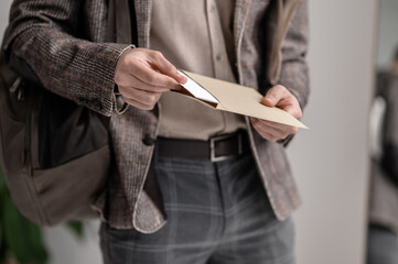 A young man in stylish jacket reading papers
