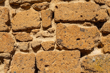 Old stone wall volcanic tuff bricks for exterior and interior wall . Close up.