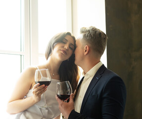 Young newlywed couple drinking wine and smiling at their happiness, romance and tenderness