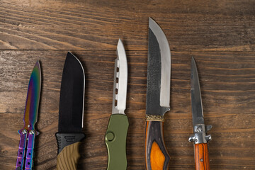 A pile of hunting knives on a table