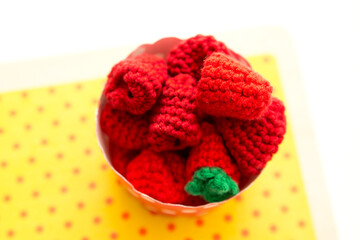 Early harvest. Hand made berries for children toy kitchen. Crocheted raspberries in paper cup.