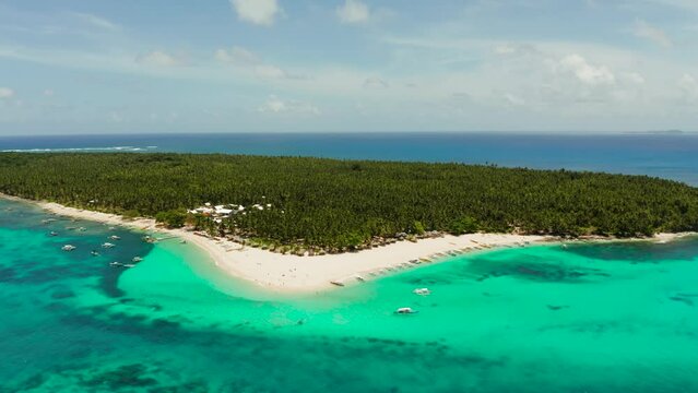 Sandy beach with tourists, palm trees and turquoise water on the island of Daco, Philippines, aerial view. Summer and travel vacation concept