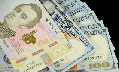 100 Ukrainian hryvnias lie on 100 dollars