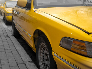 Closeup of yellow taxi cars parked on the city street