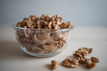 Roasted walnut and cashew, lie in a plate on the table. Protein, useful nuts. Nut Mix