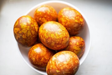 colored colorful chicken eggs in a large white plate as a symbol of the national holiday of believers