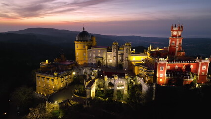 Aerial view of stunning Pena Castle at night. Top view of illuminated Sintra
