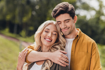 Fototapeta premium Portrait of beautiful handsome adorable dreamy couple hugging cuddling enjoying weekend idyllic harmony time outdoors