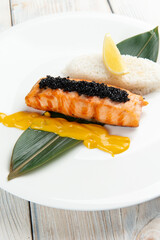 Salmon steak and rice in a bowl. On a light background.