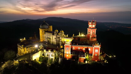 Naklejka premium Aerial view of stunning Pena Castle at night. Top view of illuminated Sintra