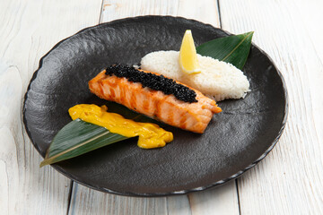 Salmon steak and rice in a bowl. On a light background.