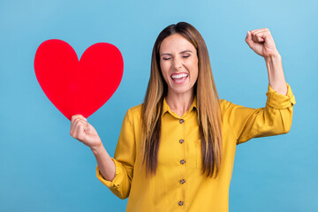 Photo of cool young brown hairdo lady hold heart yell wear yellow shirt isolated on blue color background