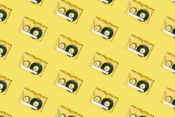 Retro pattern made with cassette tape on vibrant yellow background. Minimal nostalgia layout.