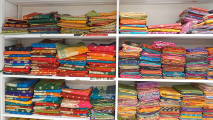 Colorful sarees or saris are arrange on racks and display in a retail shop, for use as indian...