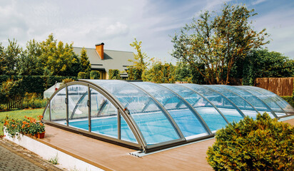 Polycarbonate Cover. Outdoor swimming pool with automatic pool cover in the garden.
