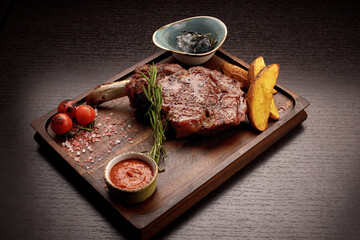 Meat steak on the bone with sauce and potatoes