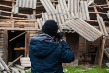 photographer photographing a destroyed house
