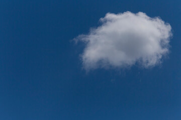 Fototapeta na wymiar small white cloud in a blue sky