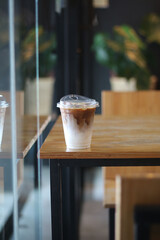 Closeup of Iced Caramel Macchiato at the coffee shop, Caramel Macchiato is a classic macchiato beverage. It consists of vanilla syrup, espresso, steamed milk, foam, and caramel drizzle