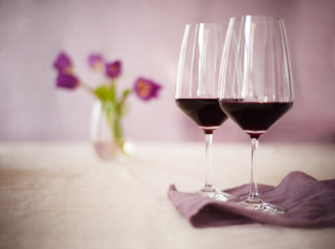 Two Glasses of Burgundy Wine With Purple Flowers in the Background