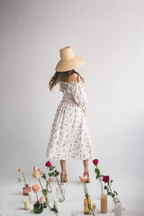 girl with flowers in a hat on a white background