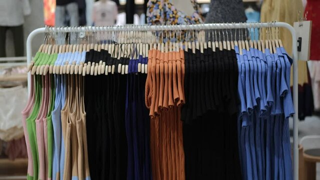 In the store, among a large assortment, there is a stand-hanger. She has clothes on it to try on something you like. Clothing attracts with its appearance, placed by colors.
