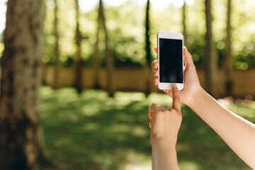 A girl is taking photos while walking in the park.