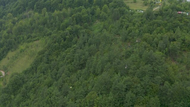 Tourists riding a zip line over the forest