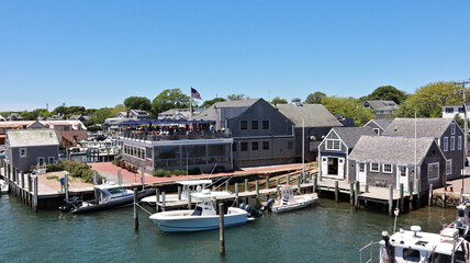 Buildings and restaurant terrace in Edgartown port with blue sky and boats