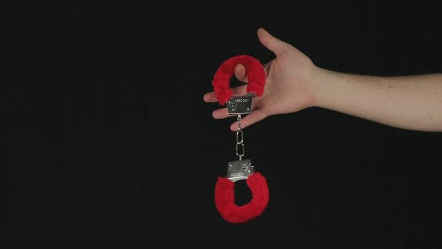 Red-edged handcuffs on a black background