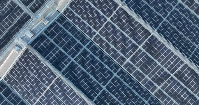 Aerial view Rooftop of industrial building with Ecology alternative solar power station on flat roof providing the residential part with renewable energy production from sun for green ecological world