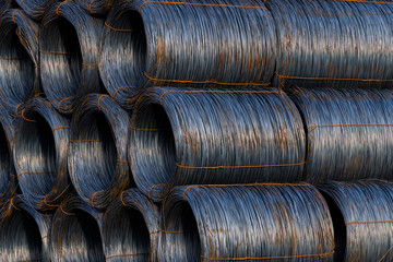 Stack of round steel wire coils at a freight station ready for transport. Metal reels for further...