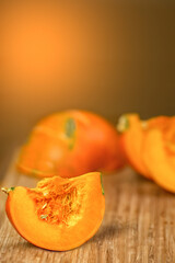 Pumpkin slices on an orange wooden background