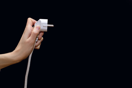 Electric plug for a socket on a black background. The concept of electricity and its importance in everyday life. Electric plug without socket. Free space for text