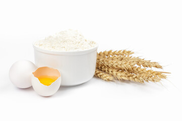 Flour, chicken eggs and ears of wheat on white background. Baking ingredients