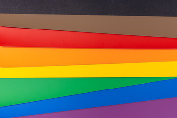 New LGBT Rainbow flag background with black and brown stripes. Group of colored cardboard. Gay...