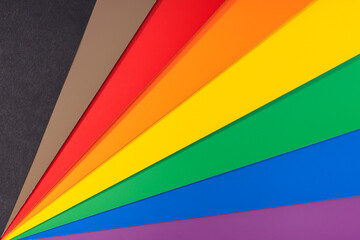 New LGBT Rainbow flag background with black and brown stripes. Group of colored cardboard. Gay...