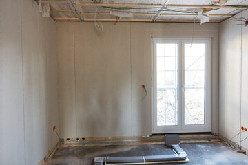 Baustelle beim Hausbau mit Terrassentür im leeren Raum