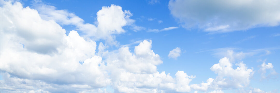 Blue sky with white cumulus clouds on a daytime. Natural panoramic background