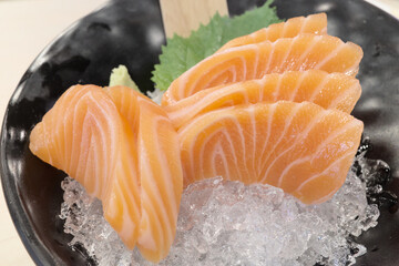 Abtract photo of delicious fresh salmon sashimi is famous recipe in restaurant. Sashimi is a Japanese delicacy consisting of fresh raw fish into thin pieces and often eaten with soy sauce.