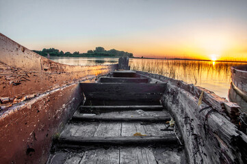 Old wooden boat on the background of the evening sunset