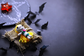 Halloween holiday concept. Old stone table in a shape of bats. Halloween paper decorations on dark background. Moon toy.