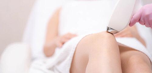 Banner Diode laser hair removal, Beautician removes hair on beautiful female legs, Hair removal for smooth skin, laser procedure at beauty studio or clinic, Body care epilation treatment.