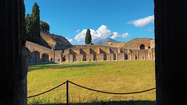 Slow pob forward showing grass field and Theatre Area of Pompeii during sunny day - Mount Ves