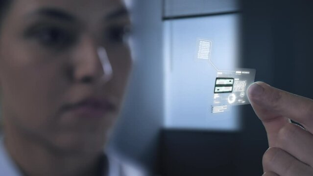 computer scientist holding a microchip processor holographic graphic interface,female design engineer in laboratory holds a futuristic micro chipset hardware,internet cyber innovation